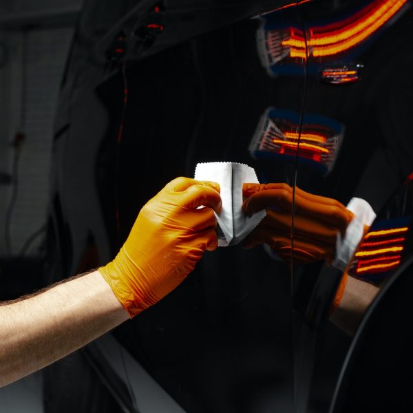 Car polish wax worker hands polishing car