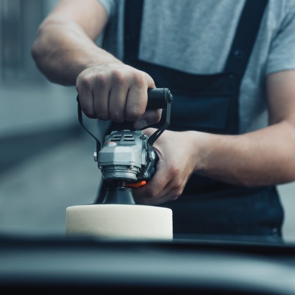 cropped view of car cleaner polishing car with buffer machine