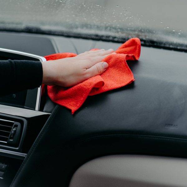 Professional cleaner and car cleaning concept. Unrecognizable man cleans car interior with cloth